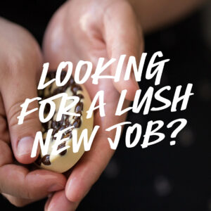 Ein Wiccy Magic Muscle Massagebar wird zwischen zwei Händen geschmolzen. Quer über dieses Bild steht der Text "Looking for a Lush new job?"