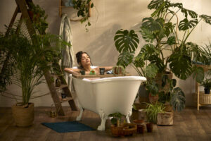 Person enjoying a bath and surrounded by a variety of indoor plants
