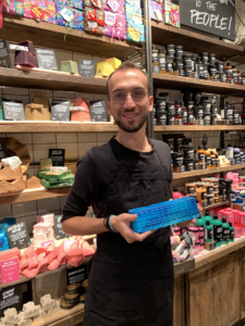 Membro staff del negozio  di Bari sorridente con it sapone Outback Mate azzurro in mano.