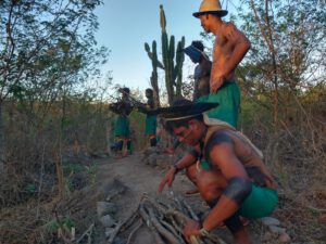 Warriors from Associação Centro de Cultura Sabuká Kariri Xocó, with firewood and cactus: Kajaby Tinga, Kayony Tinga, Vagner Cruz.