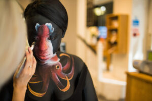 Deep sea trawling campaign. A person is having an octopus painted onto their skin