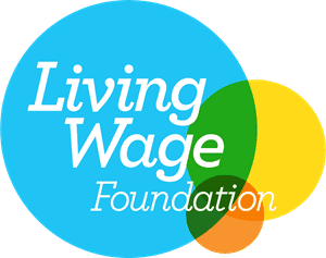 The Living Wage Foundation Logo: Three coloured circles, slightly overlapping. A large blue circle, a smaller yellow circle slightly to the right, and another smaller, orange circle underneath. White text overlapping the three circles reads 'Living Wage Foundation'.
